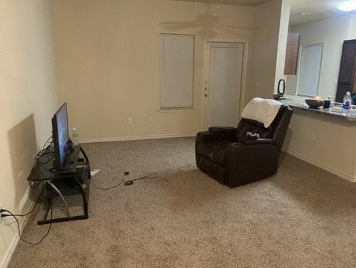 Крісло та телевізор у порожній кімнаті